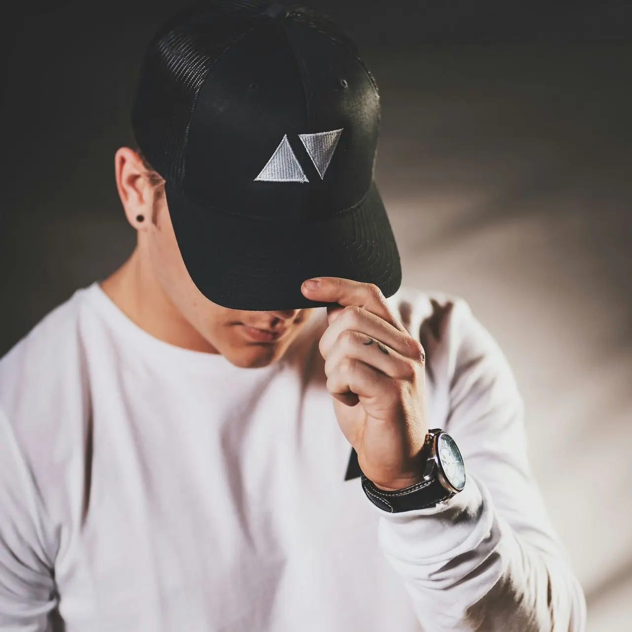 man wears black fitted cap
